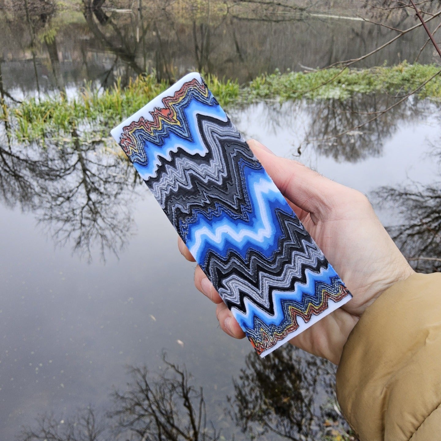 Handmade layered composite block in blue, white, and black zigzag pattern, crafted for custom tools and EDC projects.