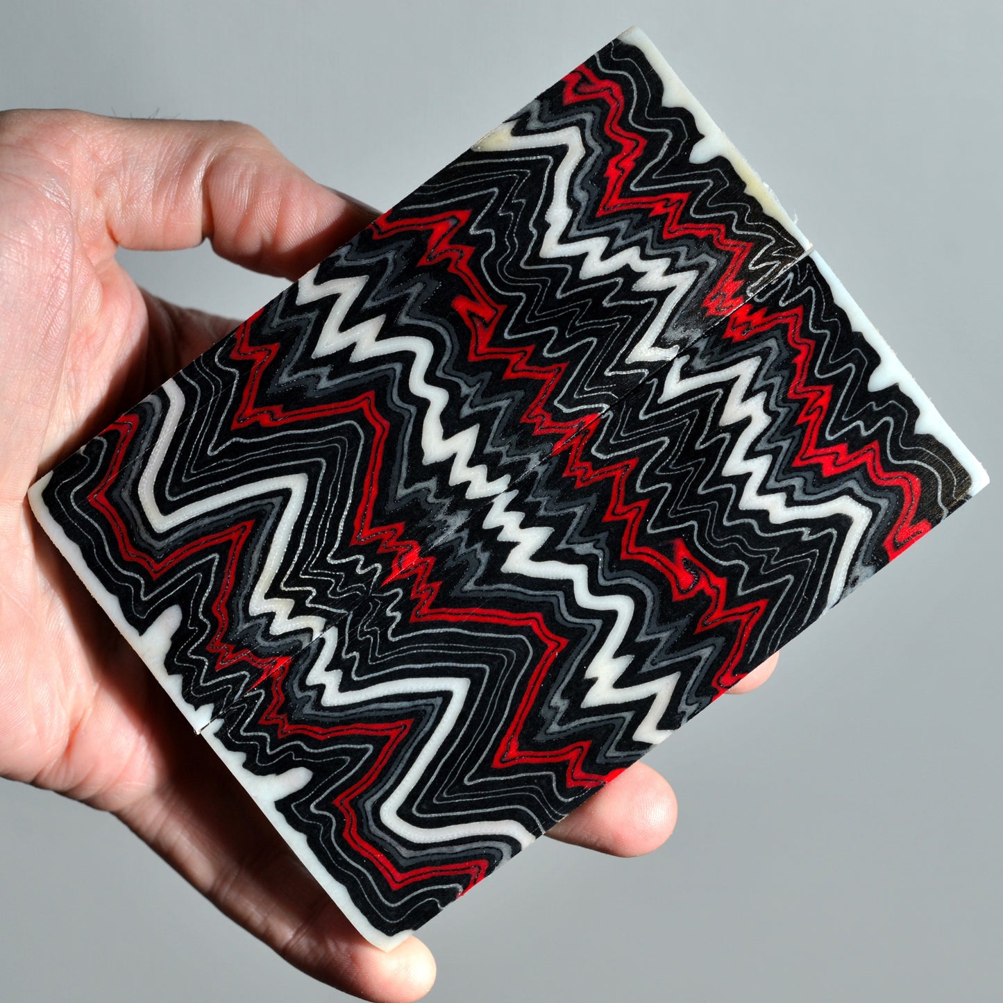 Pair of micarta knife scales with red, black and white zigzag pattern