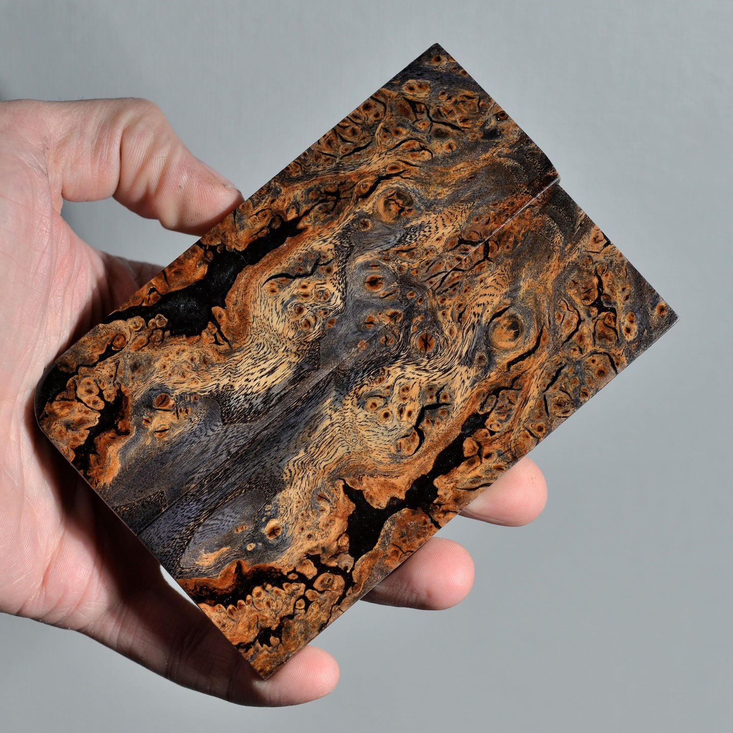 Stabilized elm burl knife handle scales with natural brown and black grain, handmade wood material