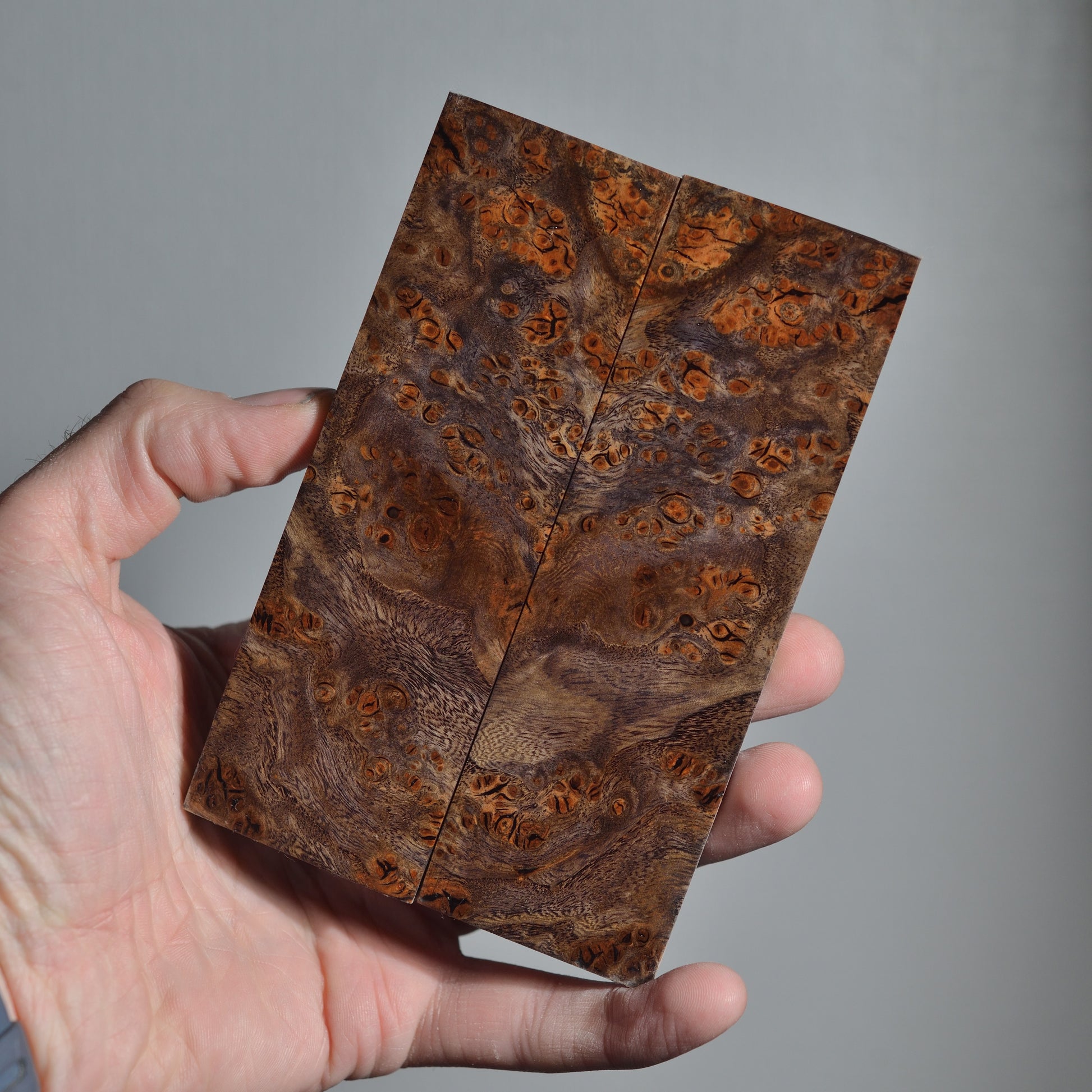 Premium stabilized wood knife scales featuring symmetrical burl pattern