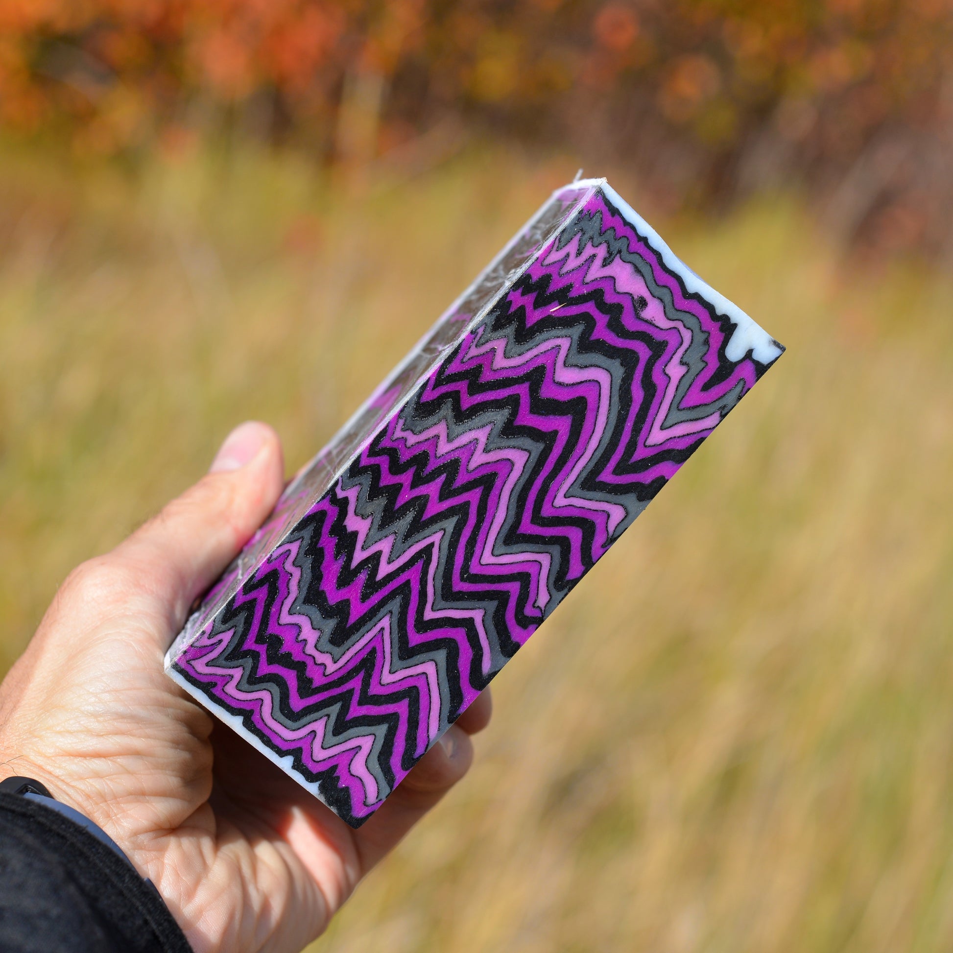 Handmade micarta knife scales with purple, black, and gray zigzag layered pattern