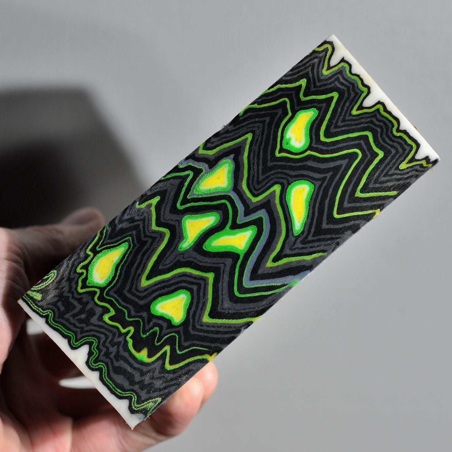 Neon green and black micarta block with abstract high-contrast pattern, composite handle material for custom knife making