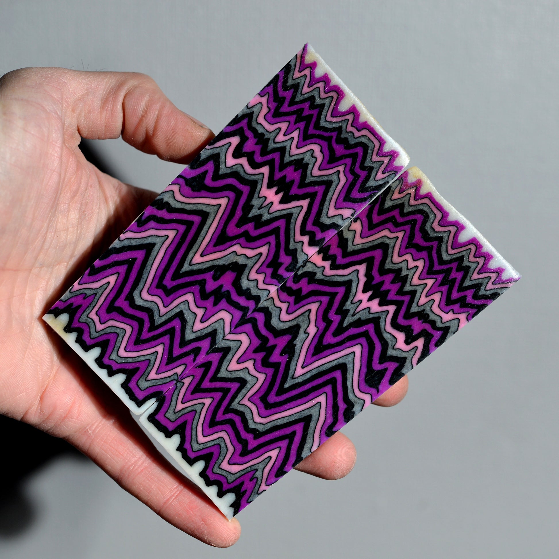 Layered micarta block with purple black and gray zigzag pattern for knife handles