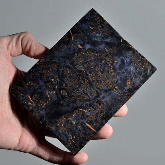 Stabilized alder burl knife handle scales pair featuring midnight blue grain with warm amber inclusions and organic burl texture.